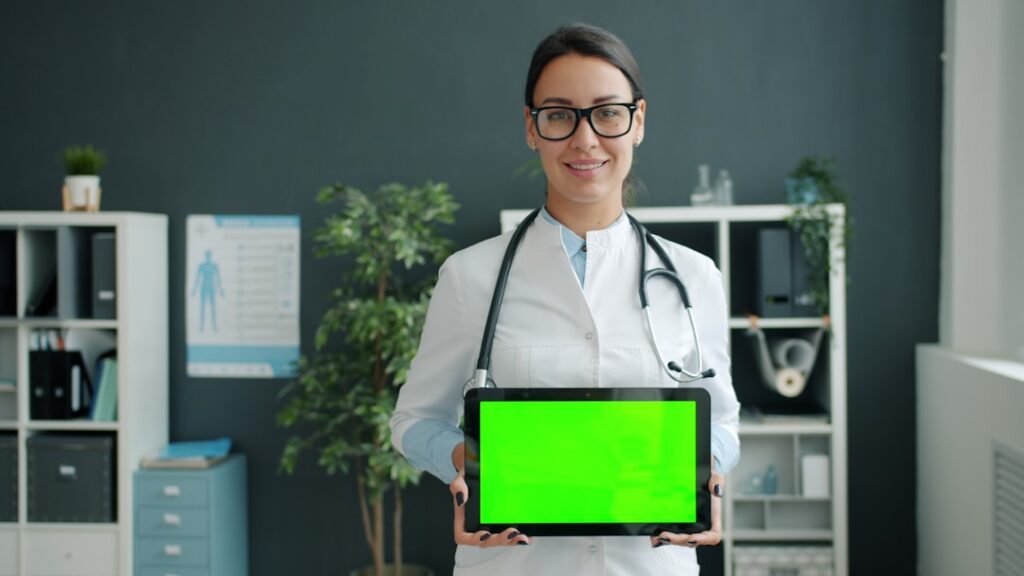 Doctor holding a tablet with a green screen.